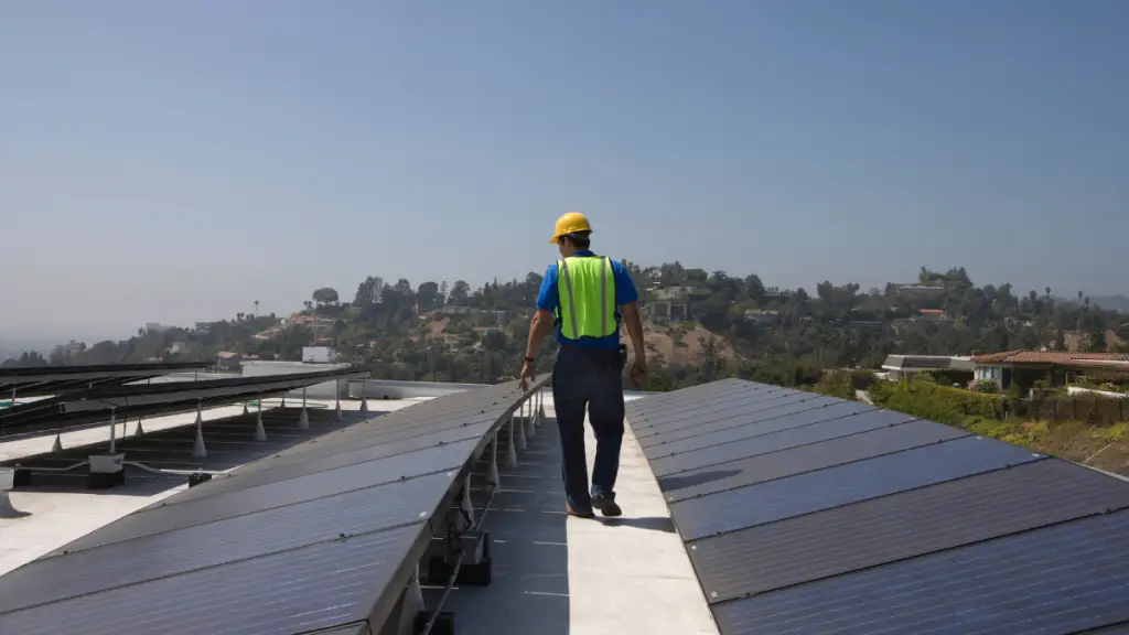 Man walking by solar panels